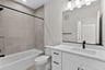 secondary bathroom with shower, tub, black hardware in sink
