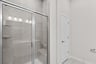 primary bathroom with shower with steel frames and closet