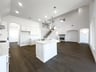 open kitchen with wood floors and white cabinets
