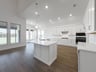 open kitchen with wood floors and white cabinets