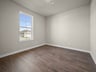 study with a window & brown flooring