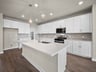 kitchen with brown flooring, pendant lighting & quartz countertops