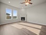 great room with brown flooring, windows & a fireplace