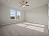 bedroom with carpet, ceiling fan & windows
