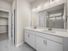 bathroom with dual sinks & a walk-in shower