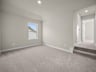 loft with carpet, windows & a sloped ceiling