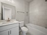 bathroom with quartz countertops & a bathtub with shower combo