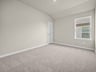 bedroom with carpet, sloped ceiling & a window