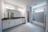 bathroom with large walk-in shower and white cabinets 