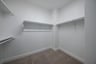 closet with hanging racks and carpet 