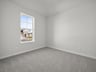 bedroom with carpet, windows & a sloped ceiling 