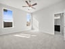bedroom with carpet, ceiling fan & windows