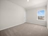 bedroom with carpet, windows & a sloped ceiling